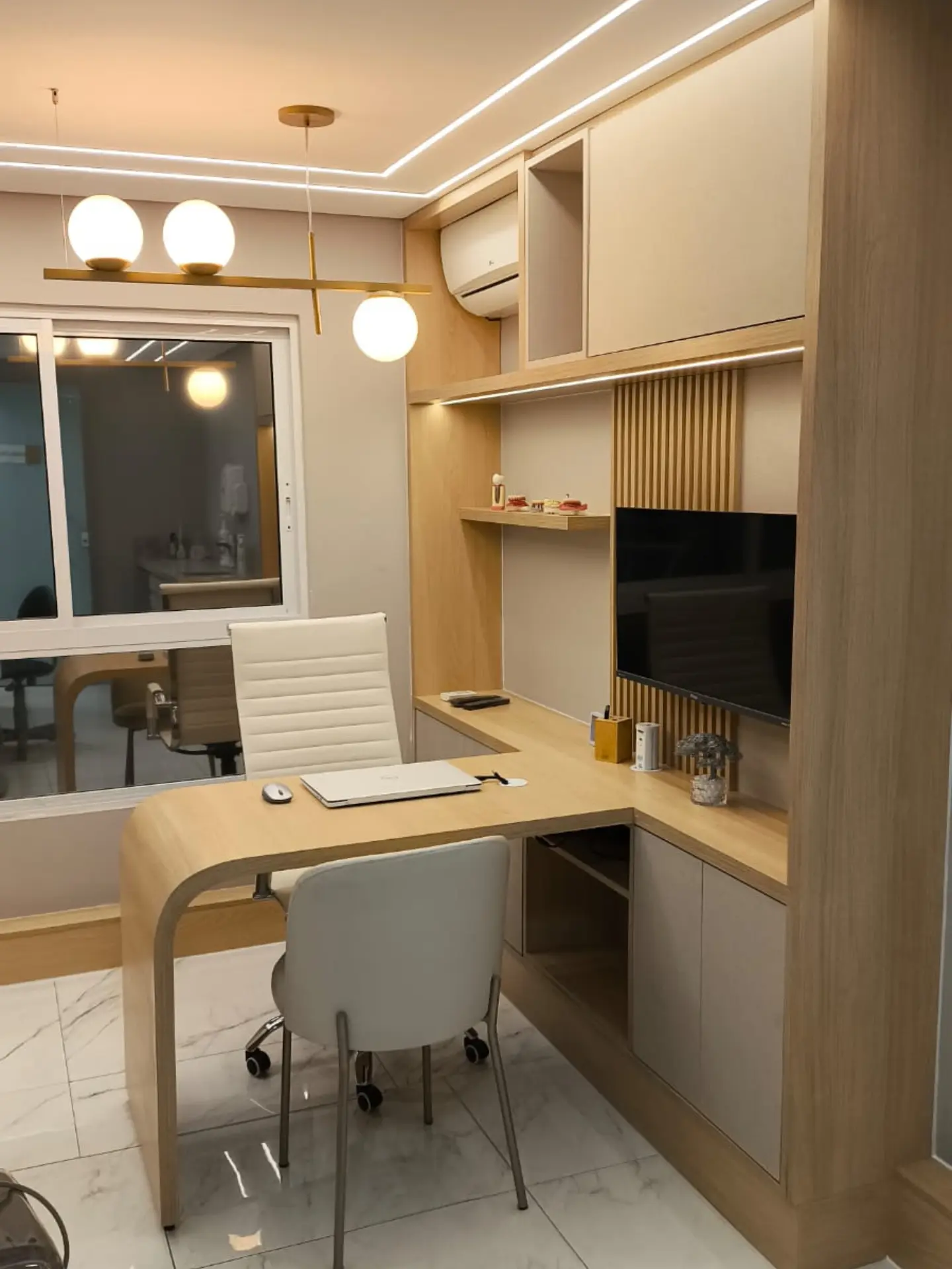 Consultório odontológico com mesa curva e nicho para TV