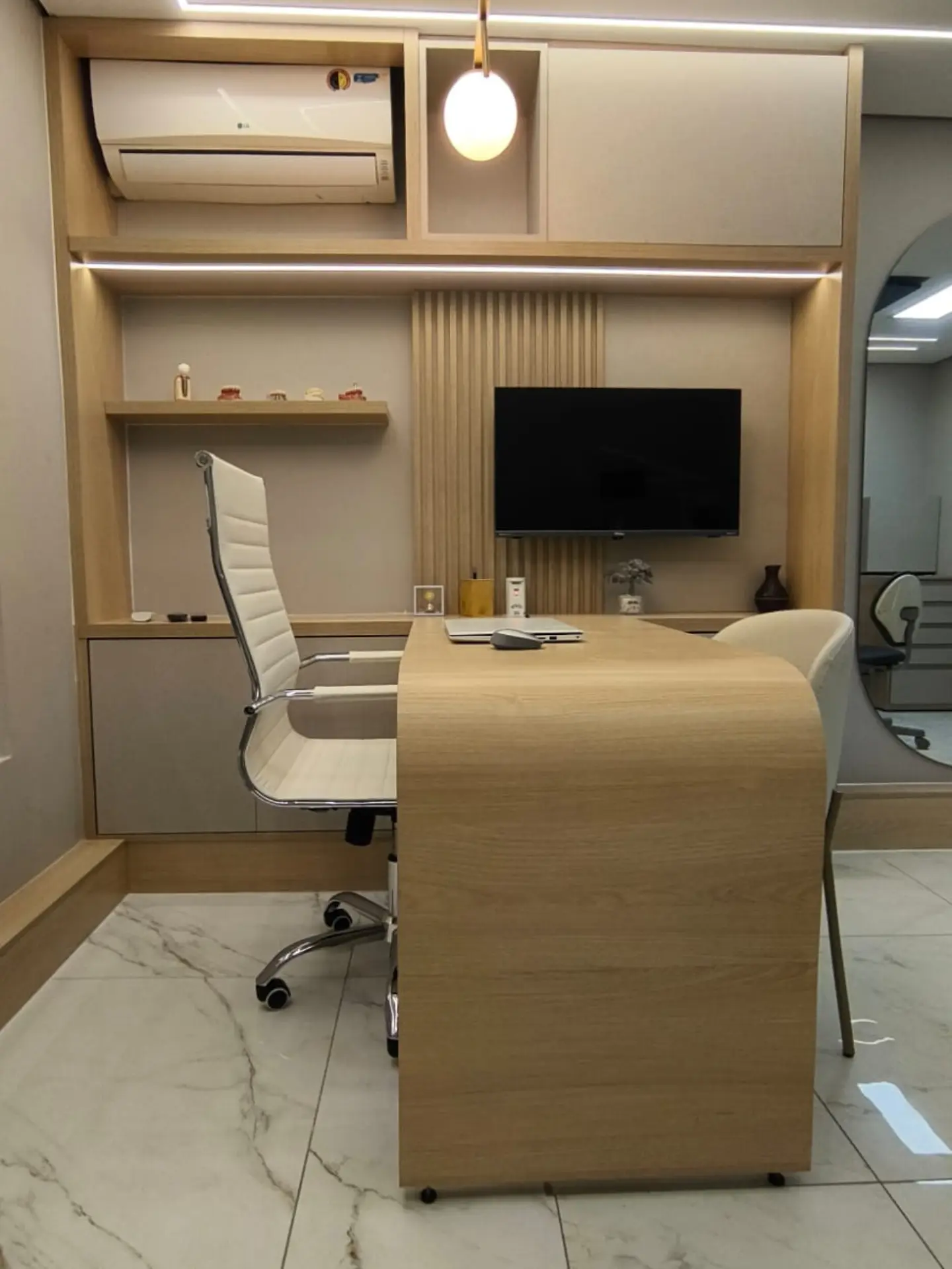 Consultório com mesa em madeira e ar-condicionado embutido